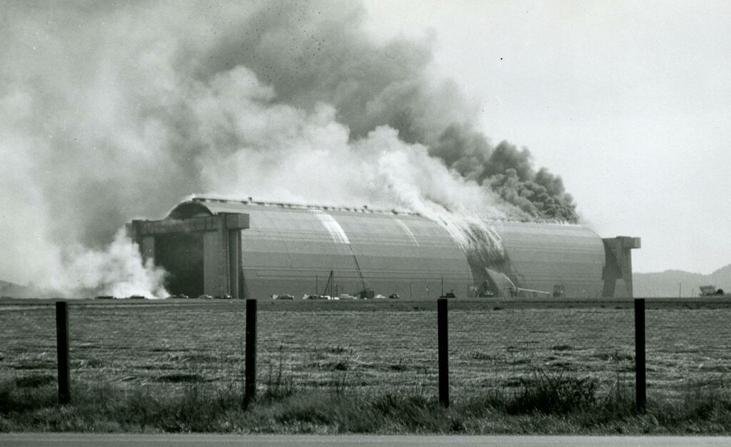 A black and white photo of air hangar B on fire in 1955. Firefighters were able to save the hangar. tillamook air museum, planes, WWII, history, family things to do, oregon coast
