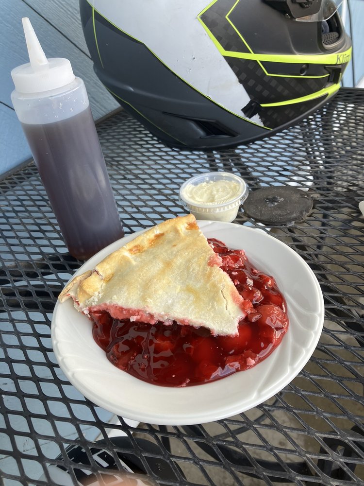 Bright red cherry pie on a white plate.