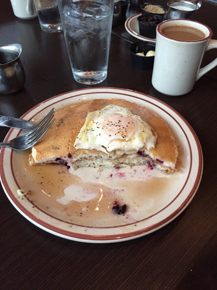 Huckleberry pancakes with a fried egg on top.