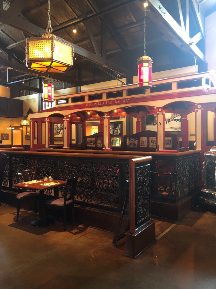 Tables and chairs outside the old red and white trolley inside The Old Spaghetti Factory.