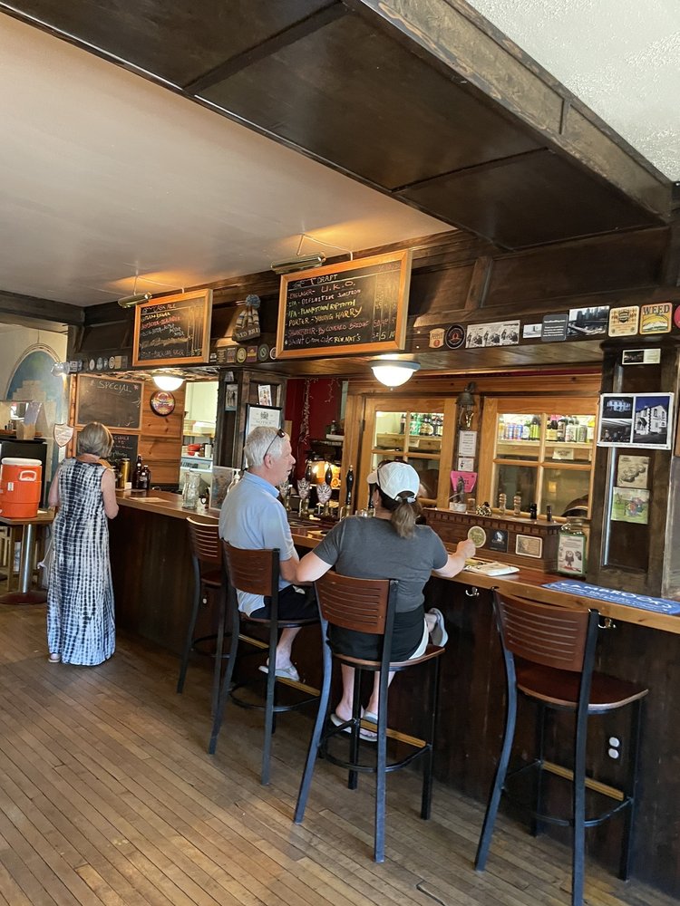 Three people at the wooden bar at The 3 Legged Crane Pub And Brewhouse in Oakridge, Oregon.