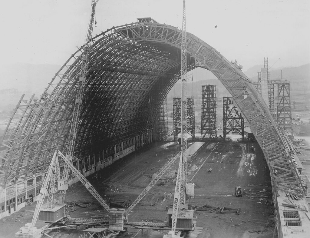 A black and white photo of a massive air hangar being constructed on a foggy day in Tillamook. tillamook air museum, planes, WWII, history, family things to do, oregon coast