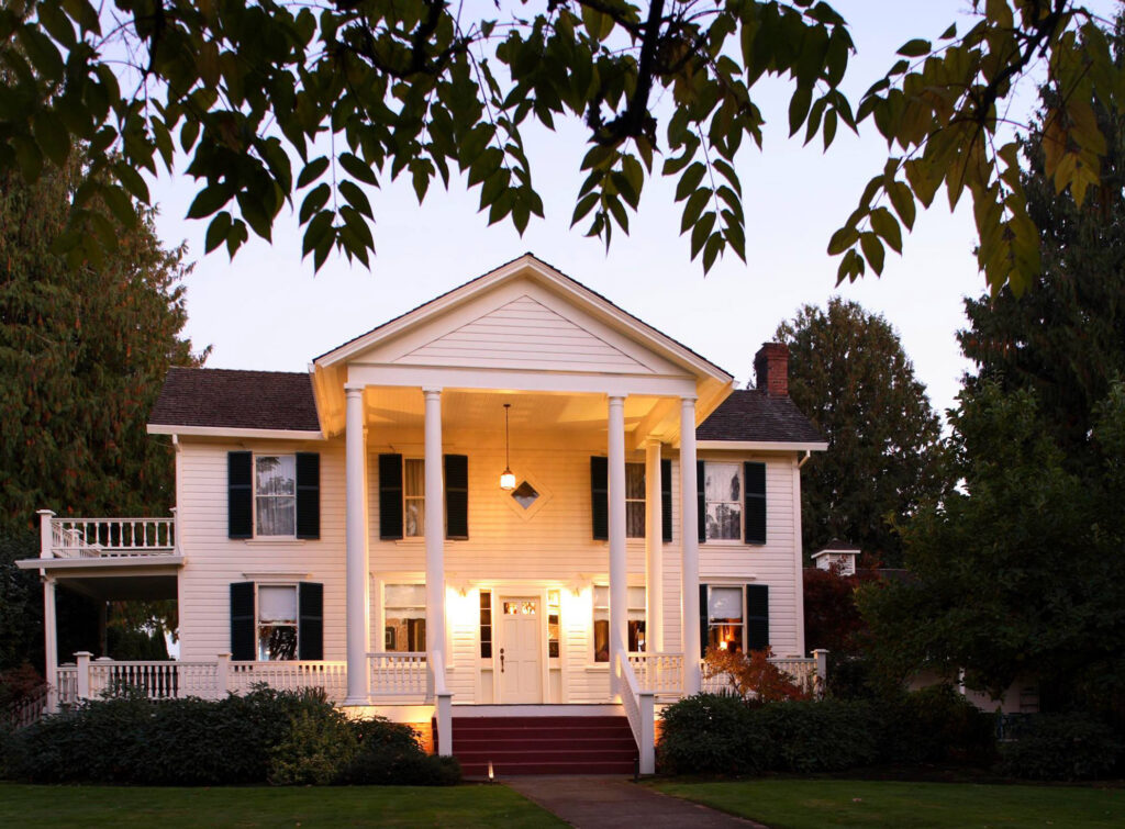 The outside of the Joel Palmer House. It's two stories, white, and has white pillars on the front porch.