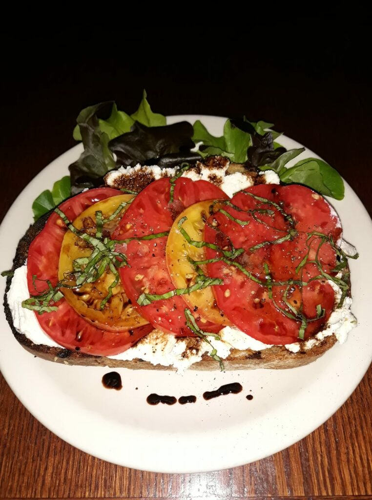 A delicious colorful plate of tomatoes with seasoning at Cassidy's Restaurant And Bar in Portland, Oregon.
