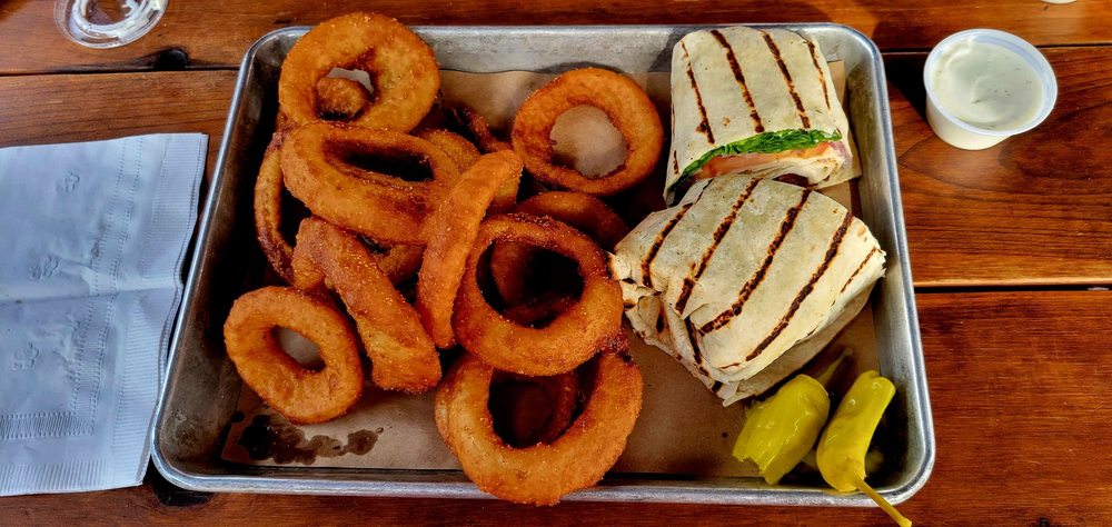 Grilled Turkey and Bacon Wrap with onion rings.