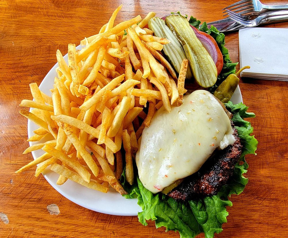 A tasty burger and a bunch of fries on a white plate.