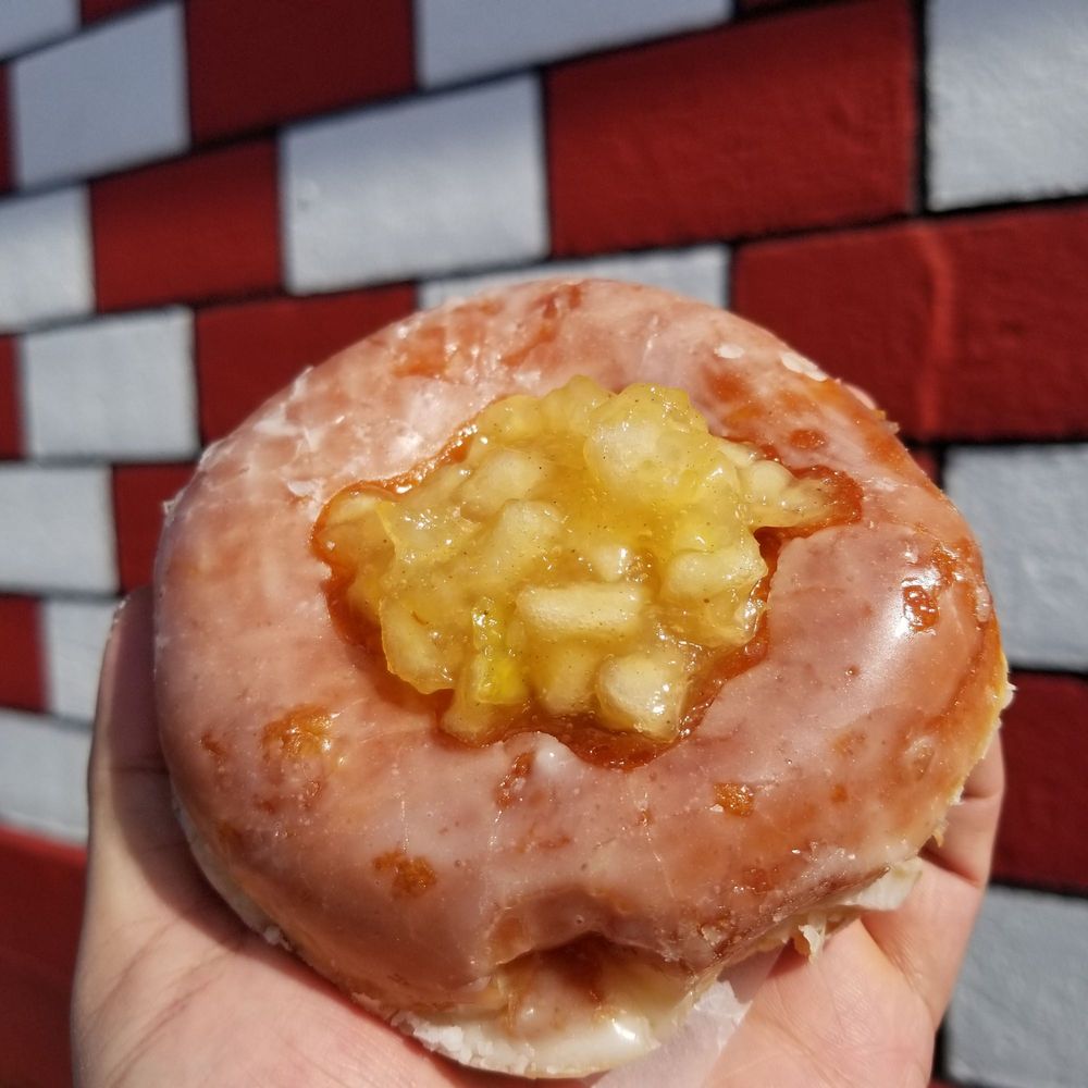 A fruit filled donut with glaze.