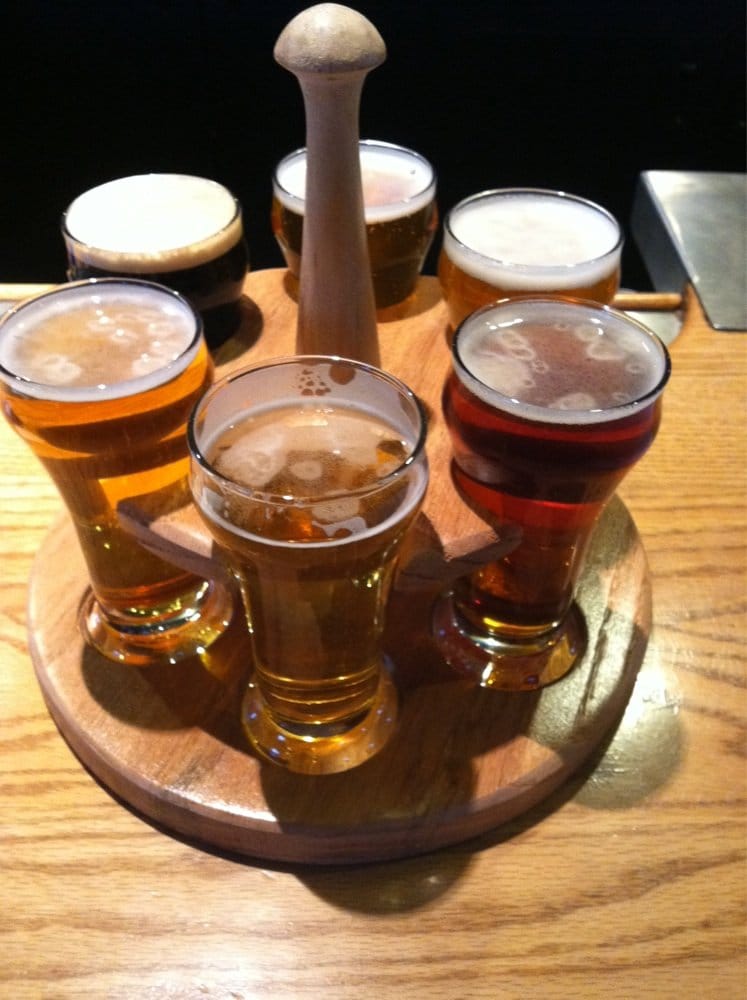 Six alcoholic drinks in a circle on a table.