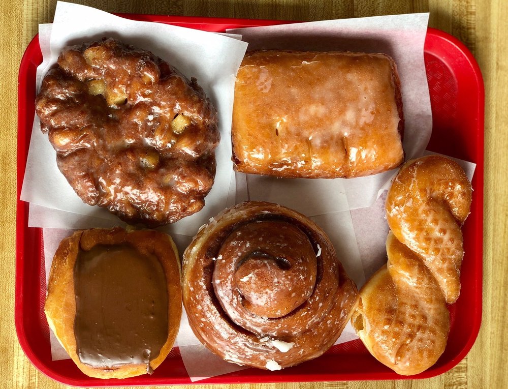 Five kinds of delicious looking donuts on a plastic tray.