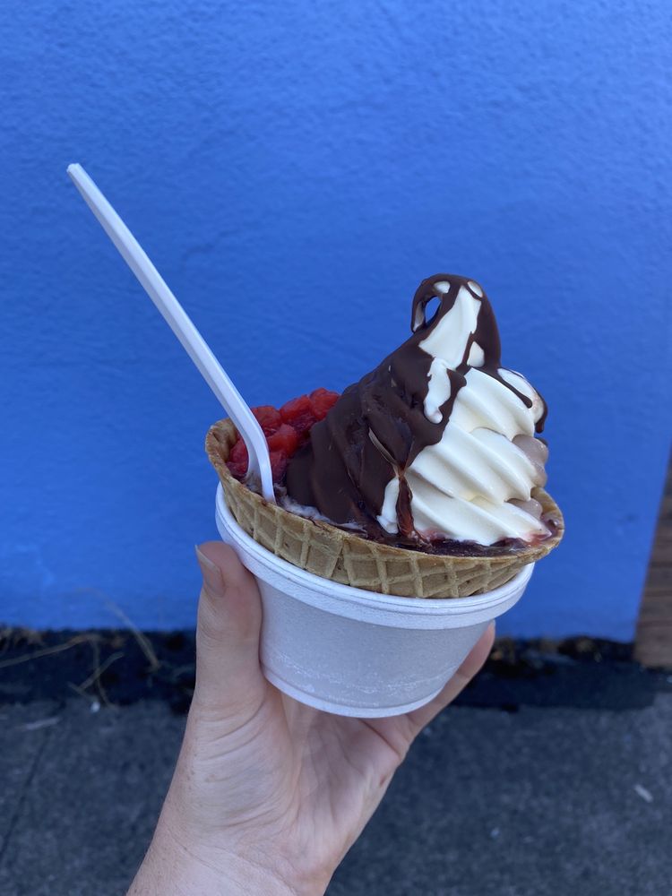 A delicious frozen custard with chocolate dip and red berries.