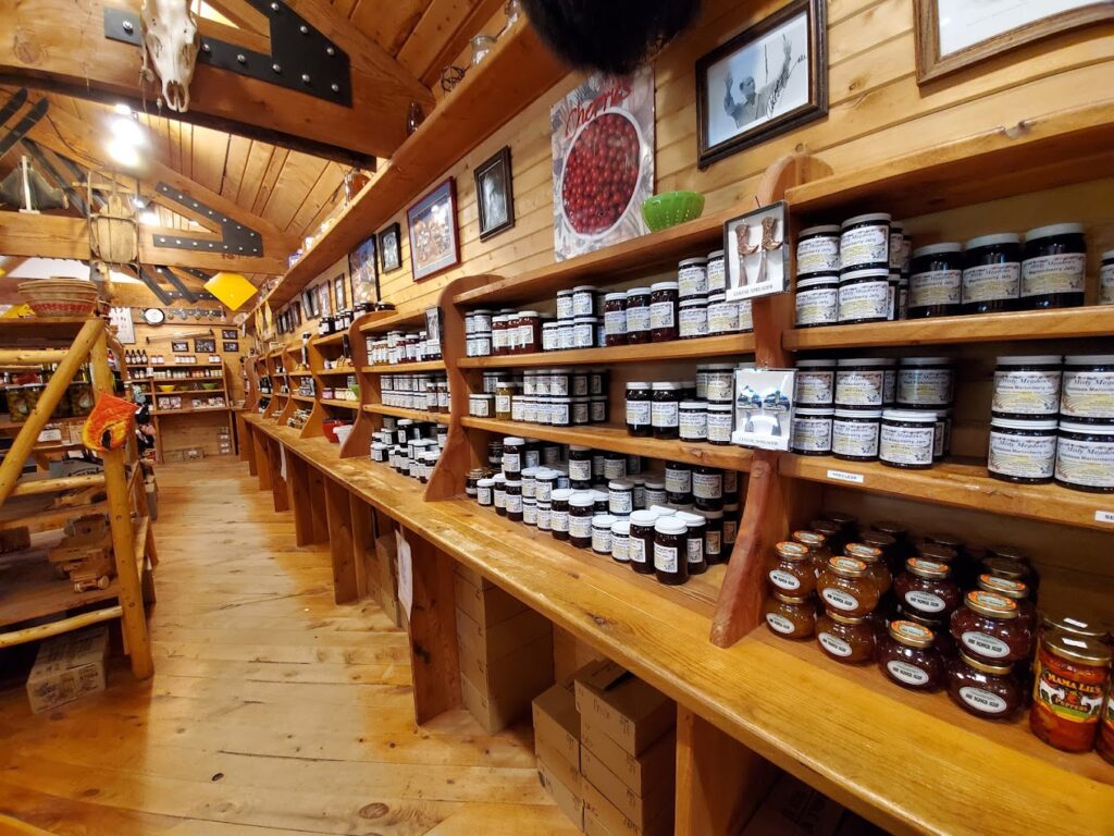 The interior of the store. It's all wood and looks like a cute wood cabin inside. There are shelves and shelves (all wood) packed with homemade jams and jellies.