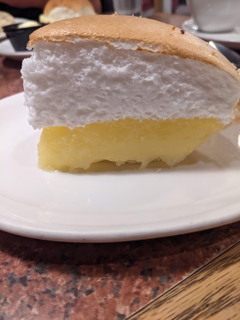 A slice of lemon meringue pie on a white plate.