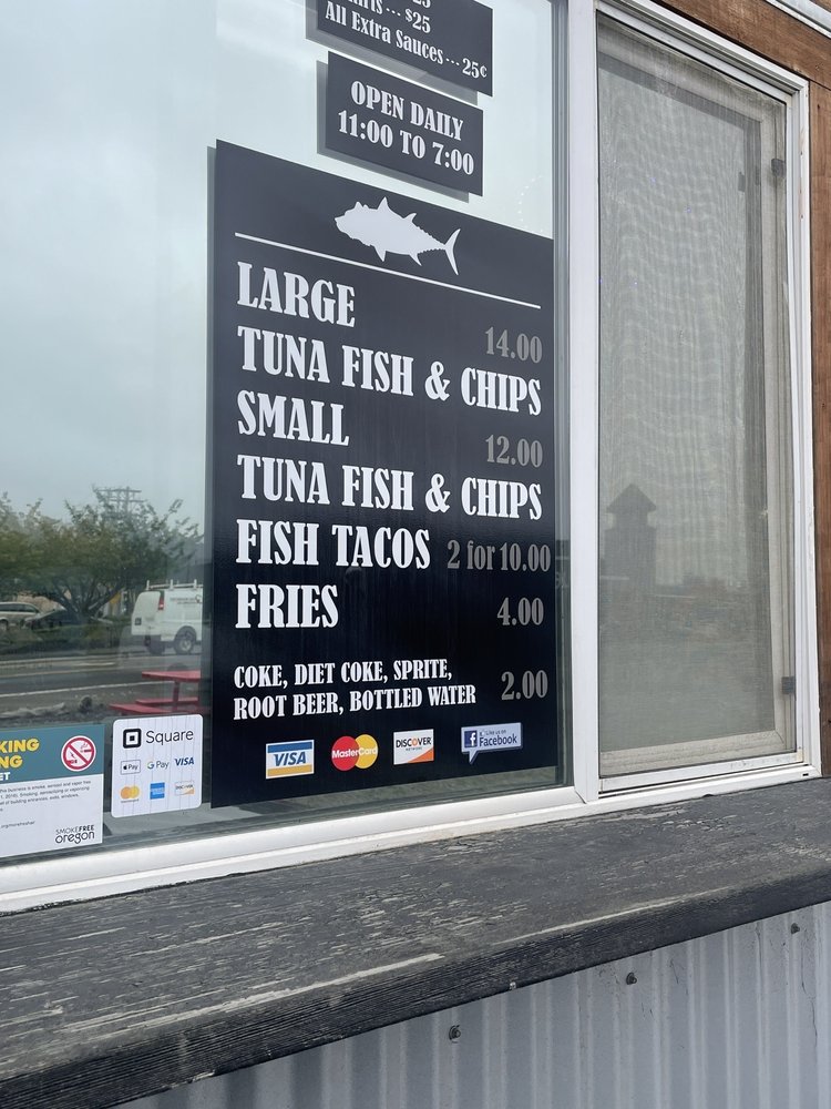 The menu on the window of Grizzly Tuna. It's a black sign with white writing.