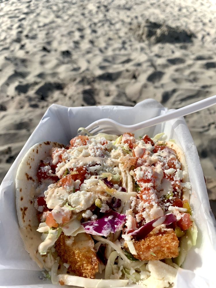 Fish Tacos in a white Styrofoam container at the beach.