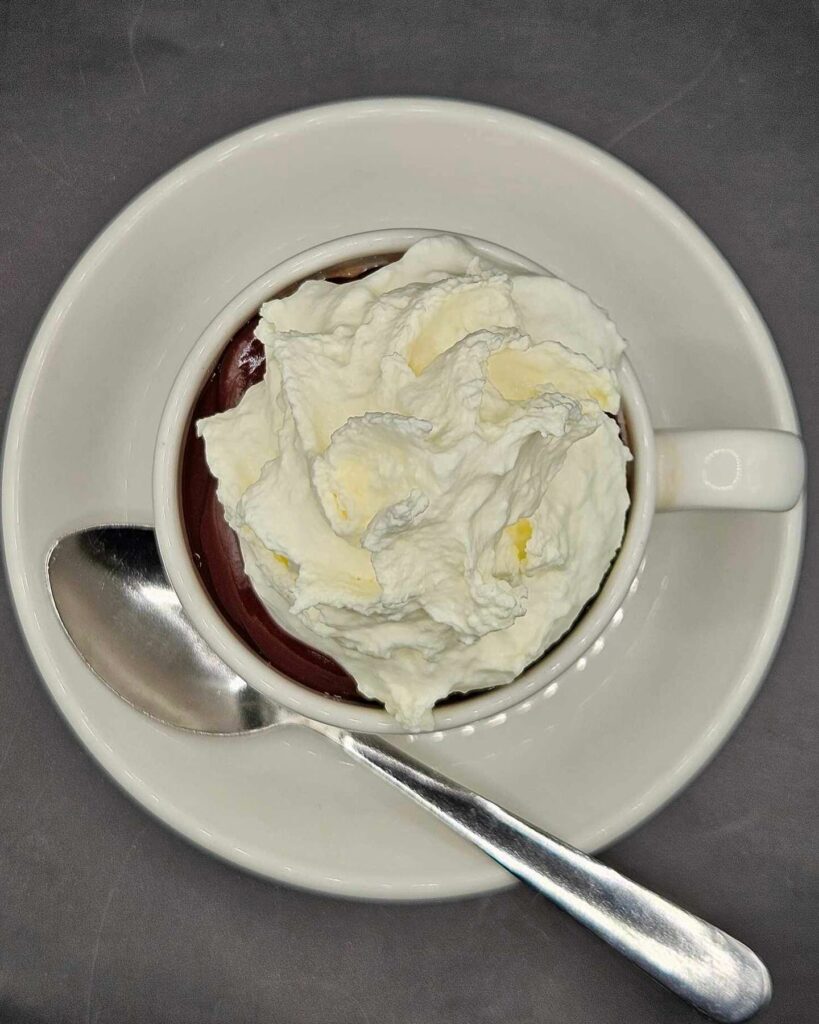 Spoon chocolate with whip cream on top.