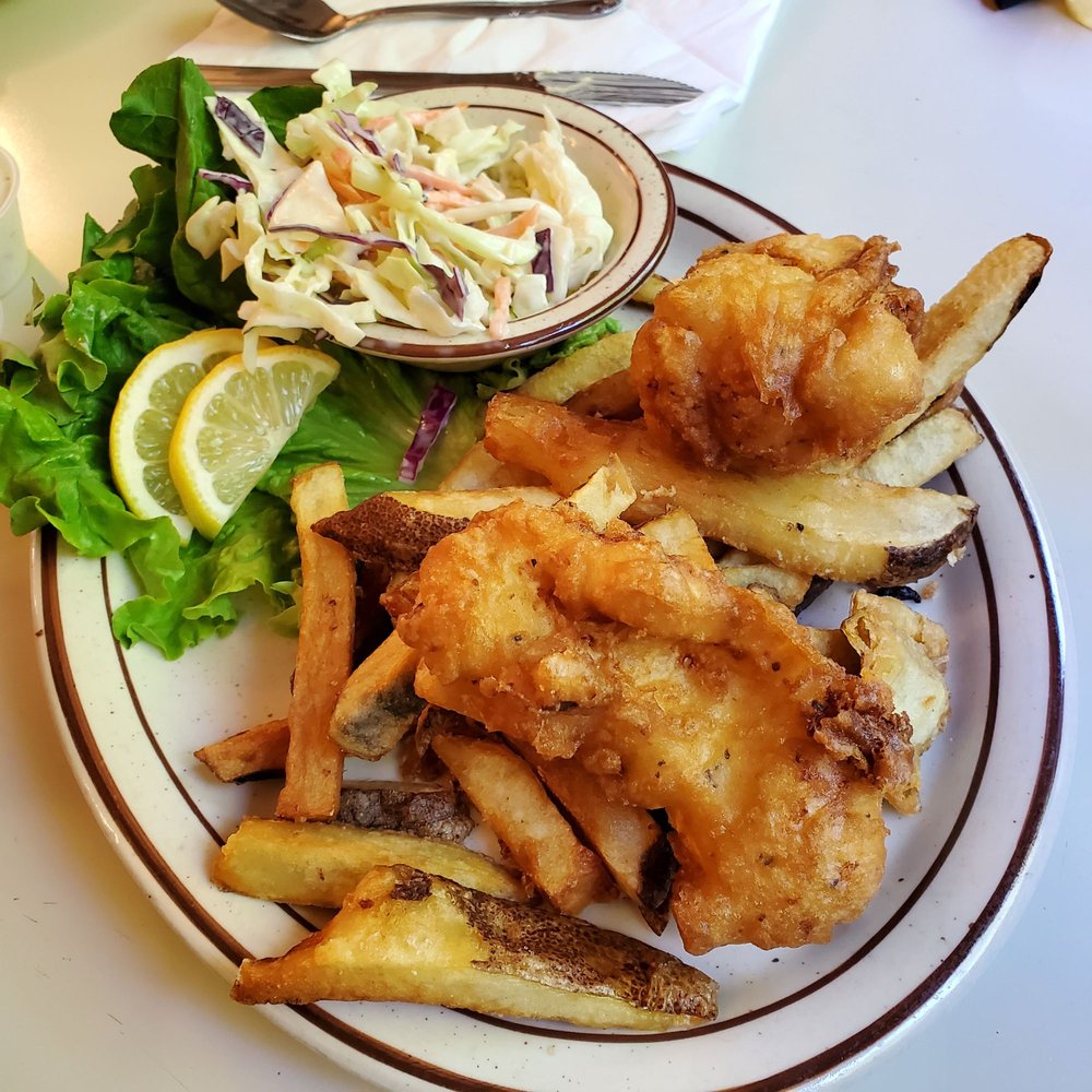 Halibut Fish And Chips on a plate with French Fries and coleslaw.