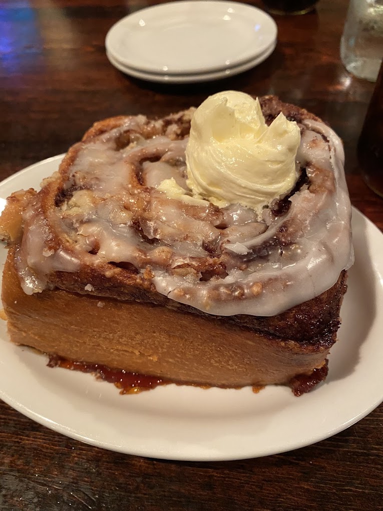 A large cinnamon roll with butter on top.