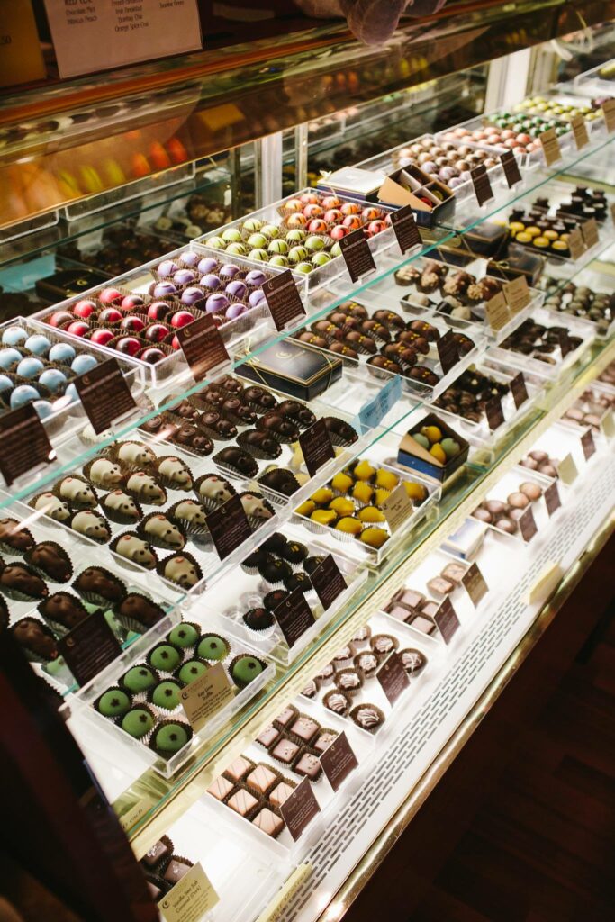 A display case with dozens of types of colorful chocolates and truffles.