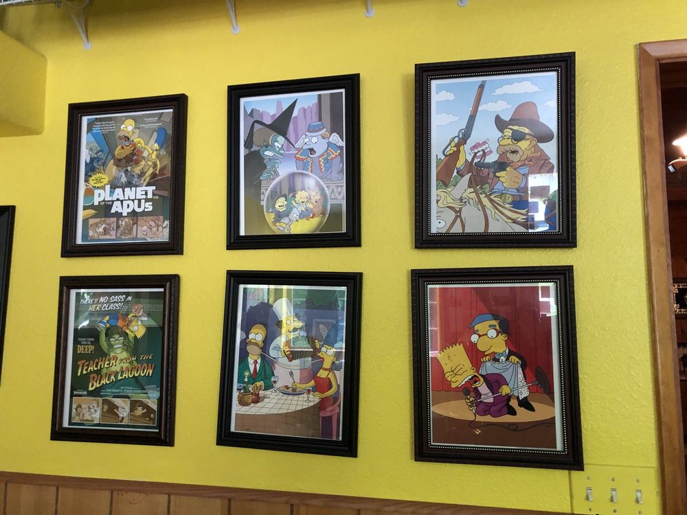 Simpson's art pieces on a bright yellow wall.