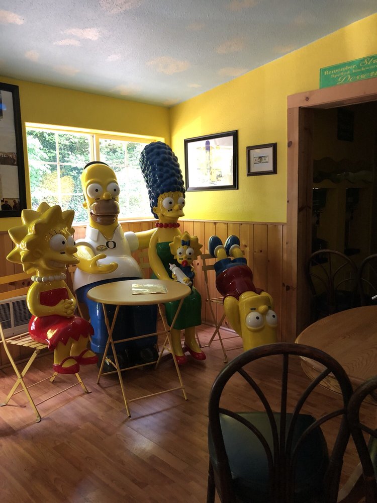 A life size statue of the Simpsons at a table in the Simpsons room at Ike's Pizza.