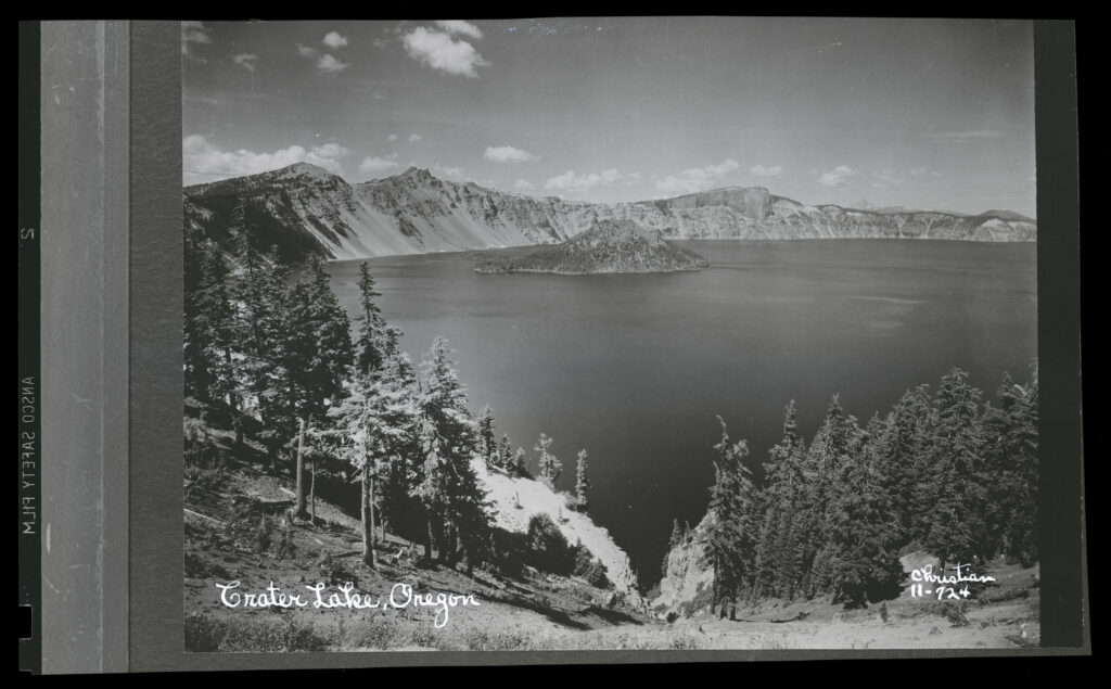 An old black and white photograph of Wizard Island and Crater Lake.