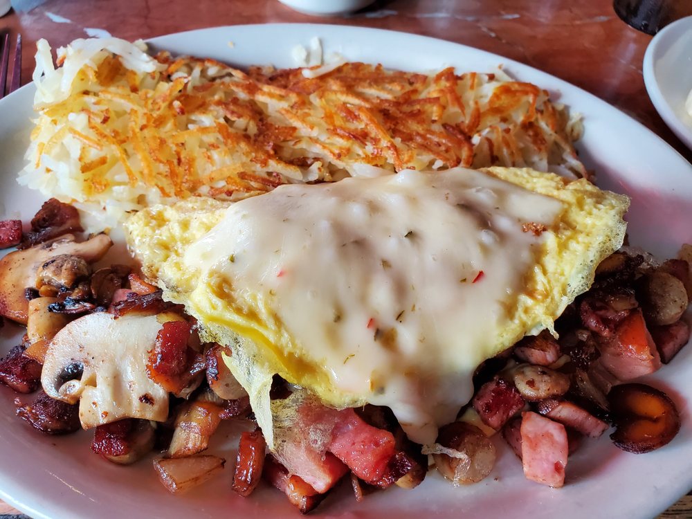 A delicious omelet with meat and hash browns.