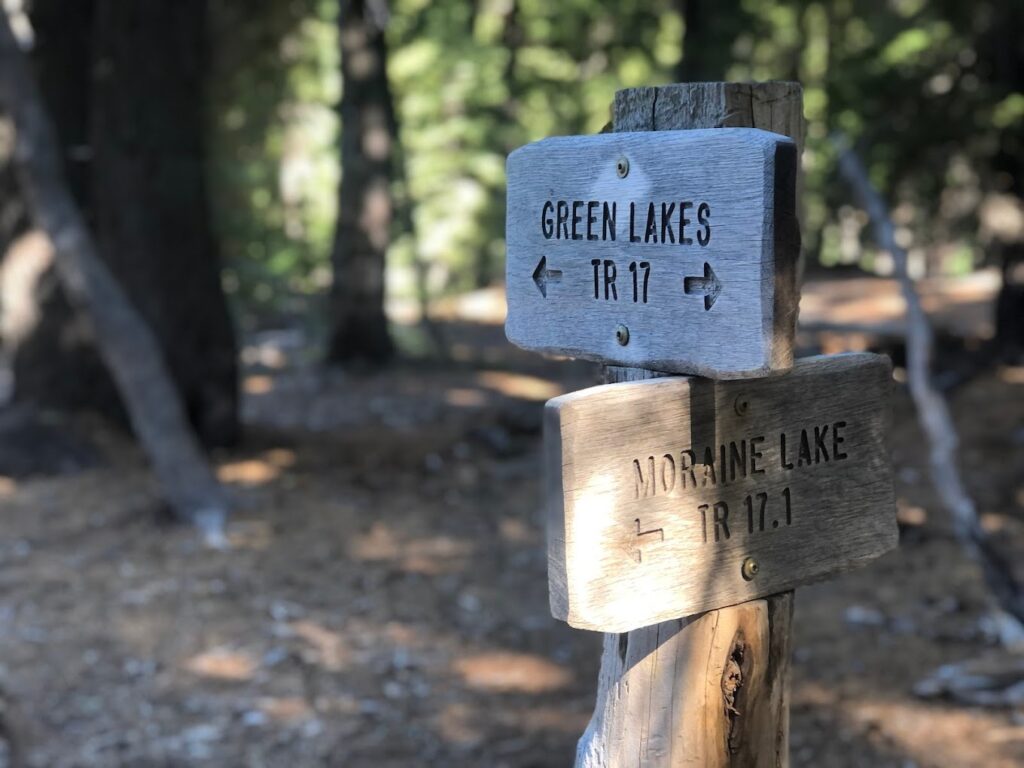 A wooden sign pointing the direction to the Green lakes Trail.