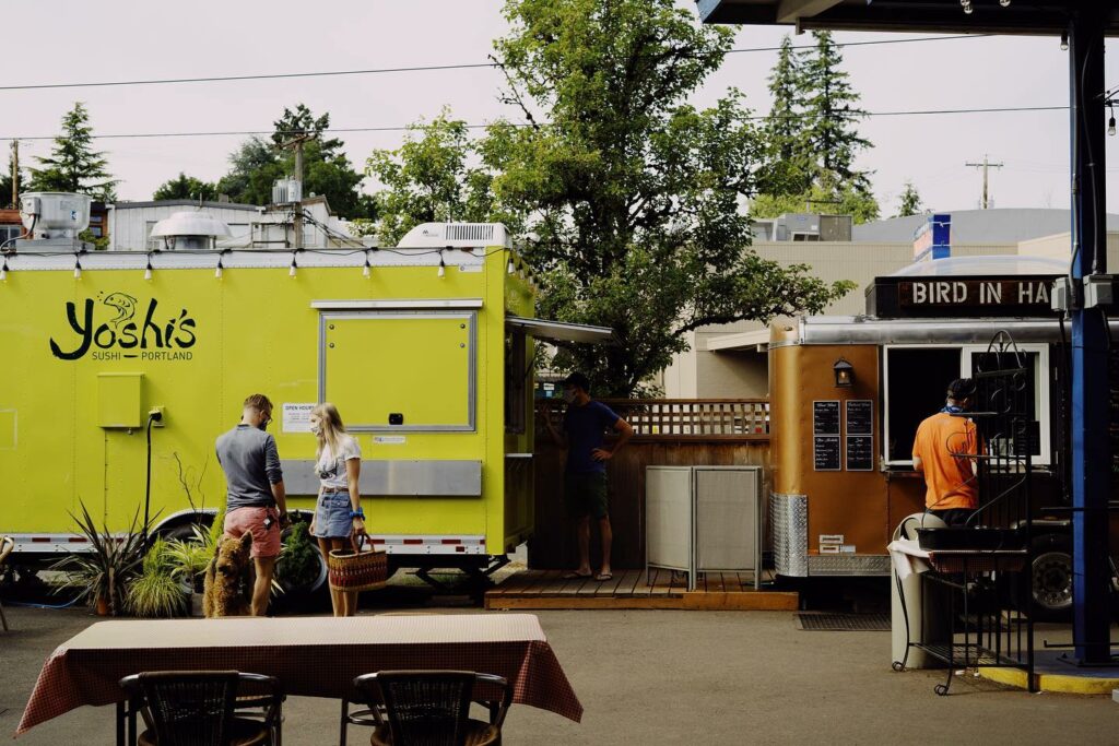 People talking outside of the Yoshi's Sushi food truck.