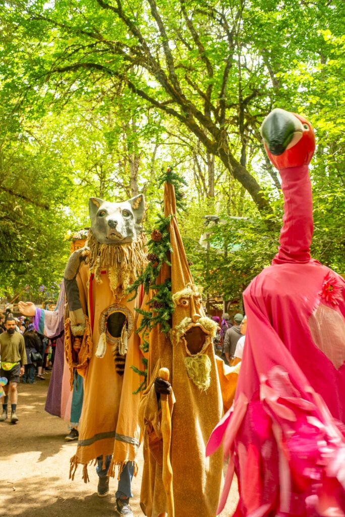 People parading down the street wearing very tall costumes.