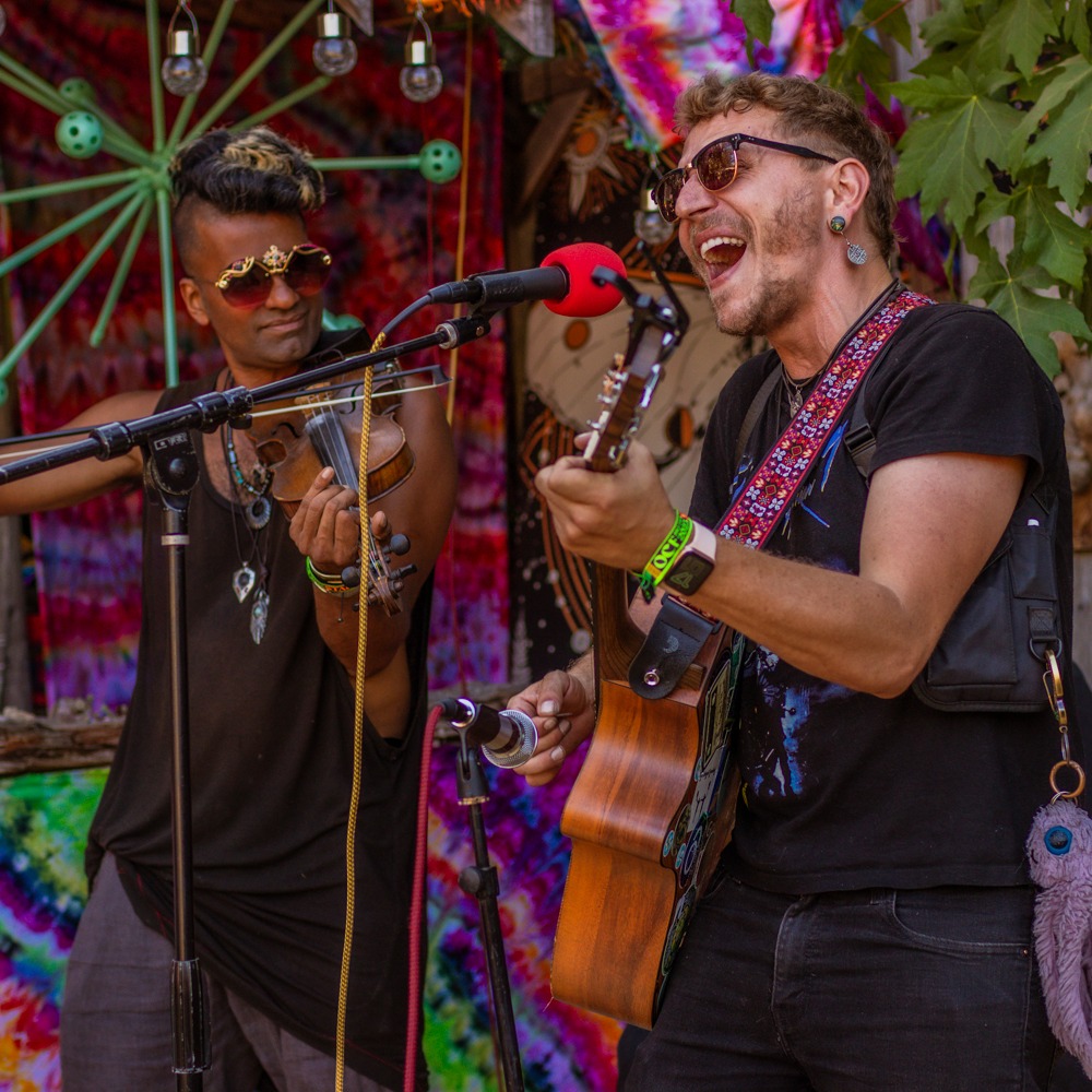 Two men sing and perform on stage.