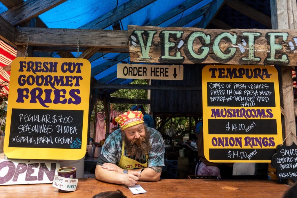 A man selling food at a popup restaurant stand.