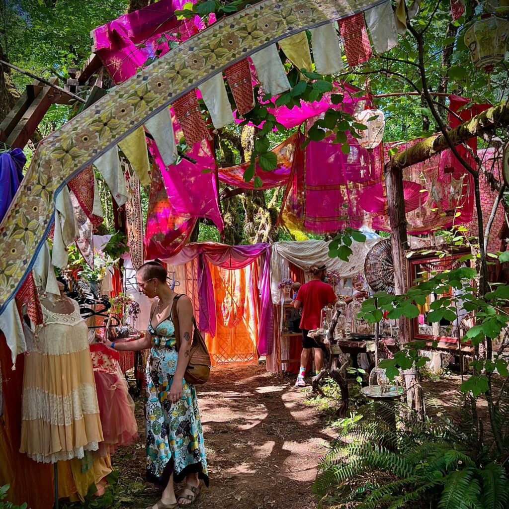 An artisan stall selling clothing items. It looks like a magical space.