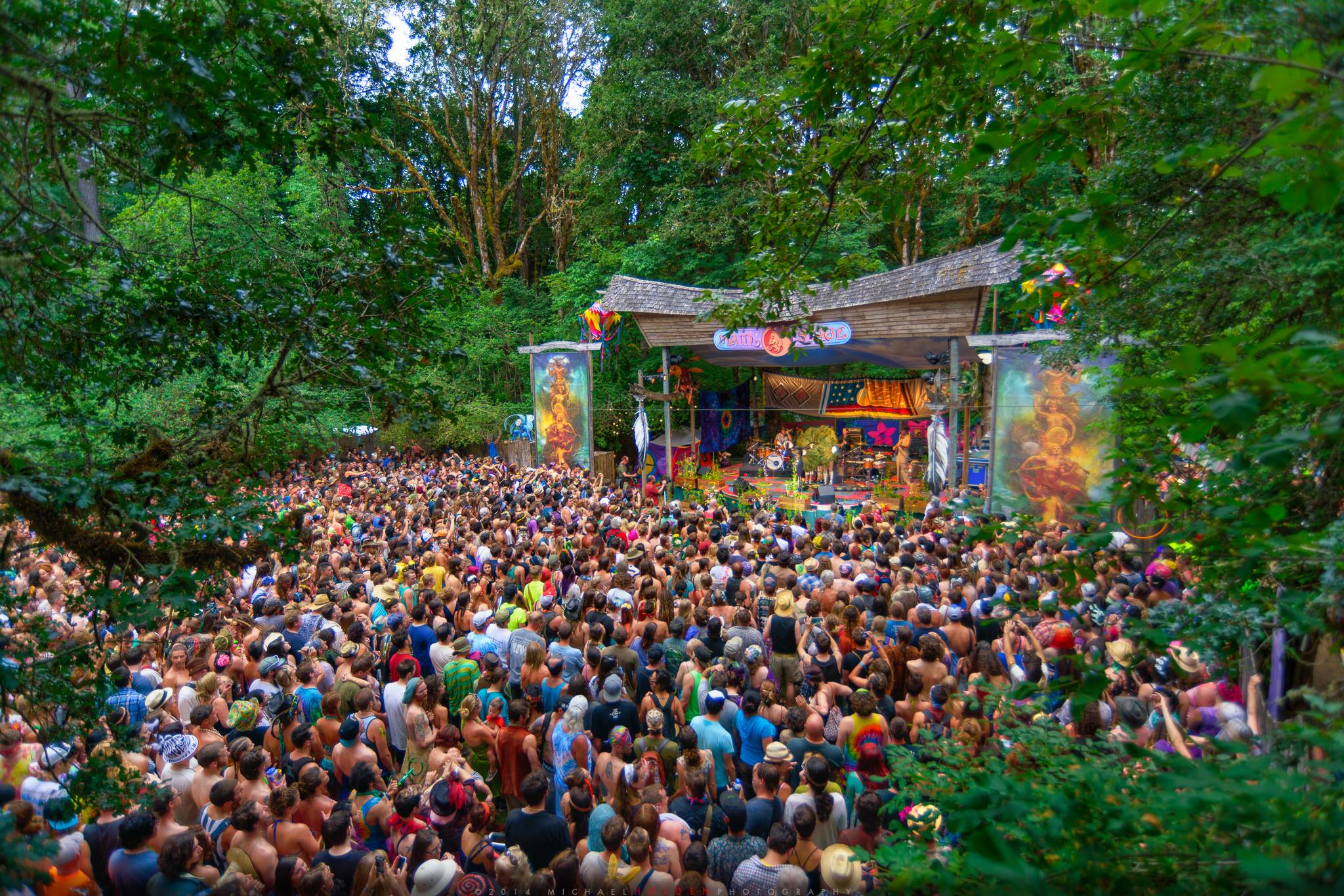 A large crowd watching a live performance in the woods. Photo via the Oregon Country Fair Facebook page.