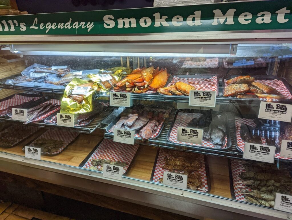 Smoked meats and jerky's behind a glass display case.