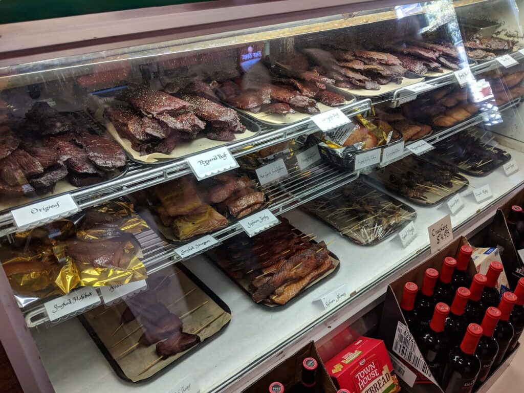 Smoked meats and jerky's behind a glass display case.