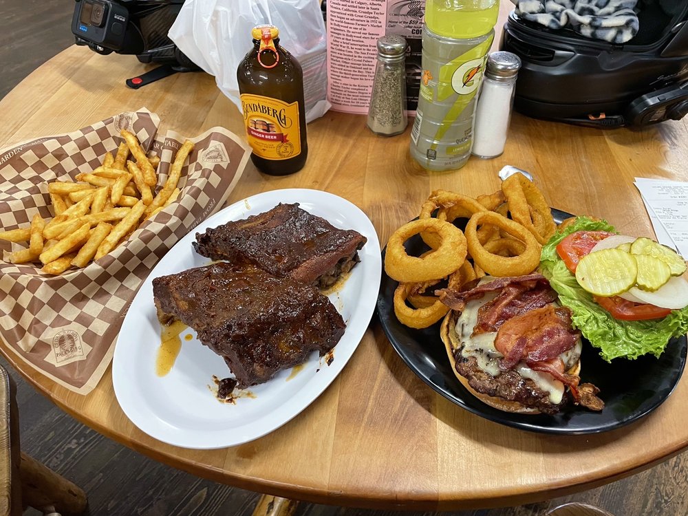 A tasty meal including meat, fries, onion rings, and a burger.