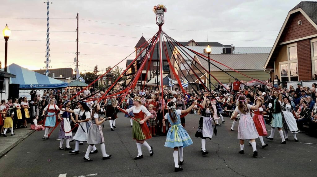 Dressed up in costume, people dance around a ribbon pole at the Mt. Angel Oktoberfest.