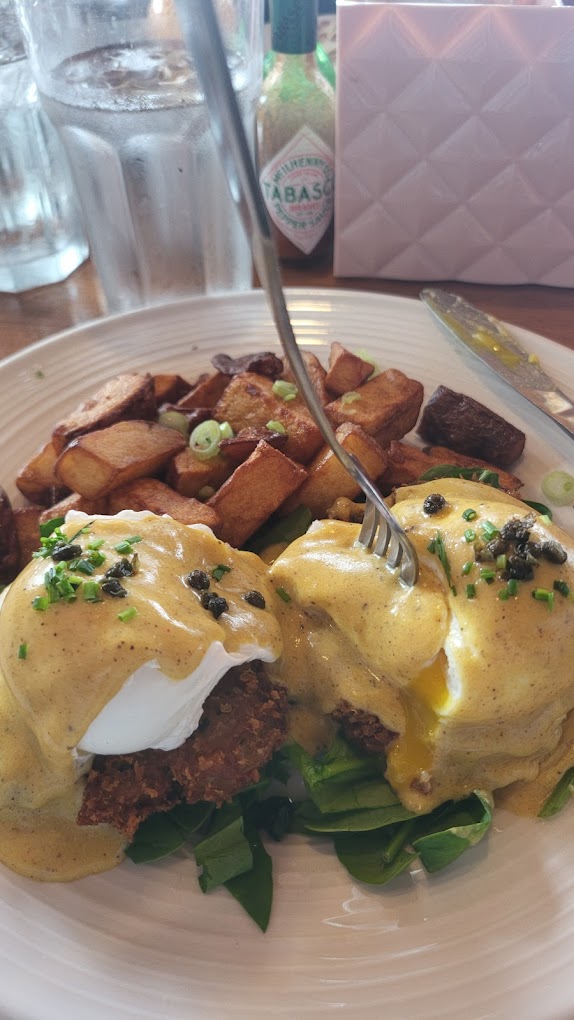 Delicious looking eggs benedict with potatoes.