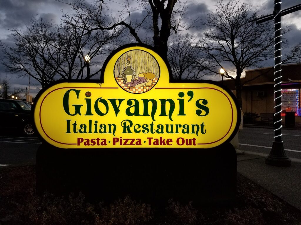 The yellow Giovanni's sign lit up at night.