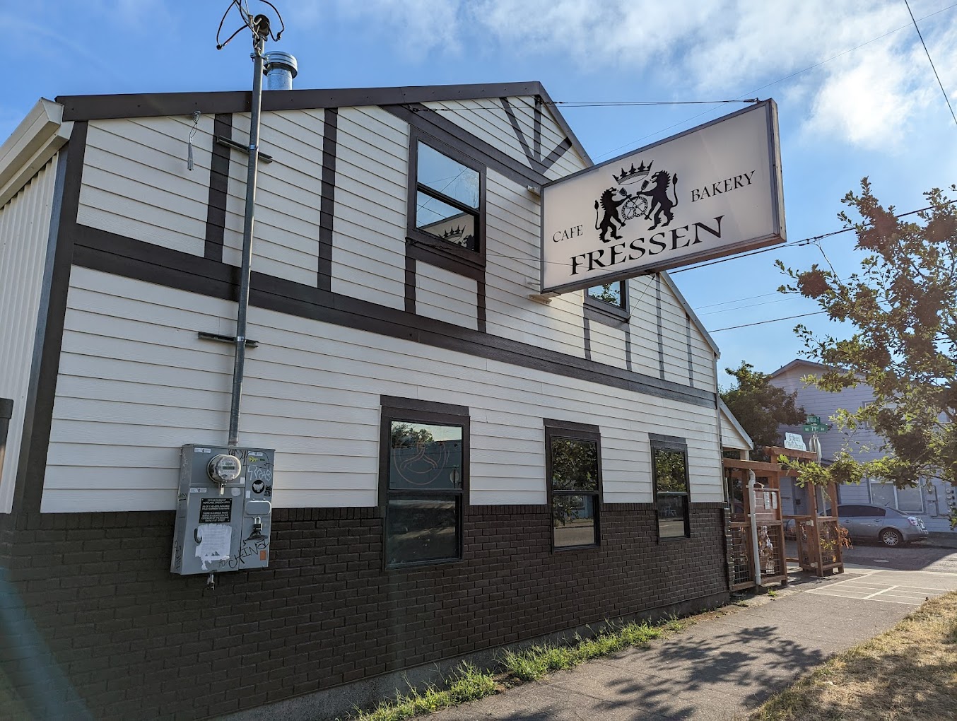 The outside of Fressen Artisan Bakery in Portland, Oregon. It's a white building with brown trim and accents.