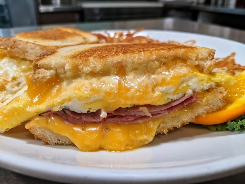 A delicious breakfast sandwich with eggs, cheese, and meat at Whites Restaurant.