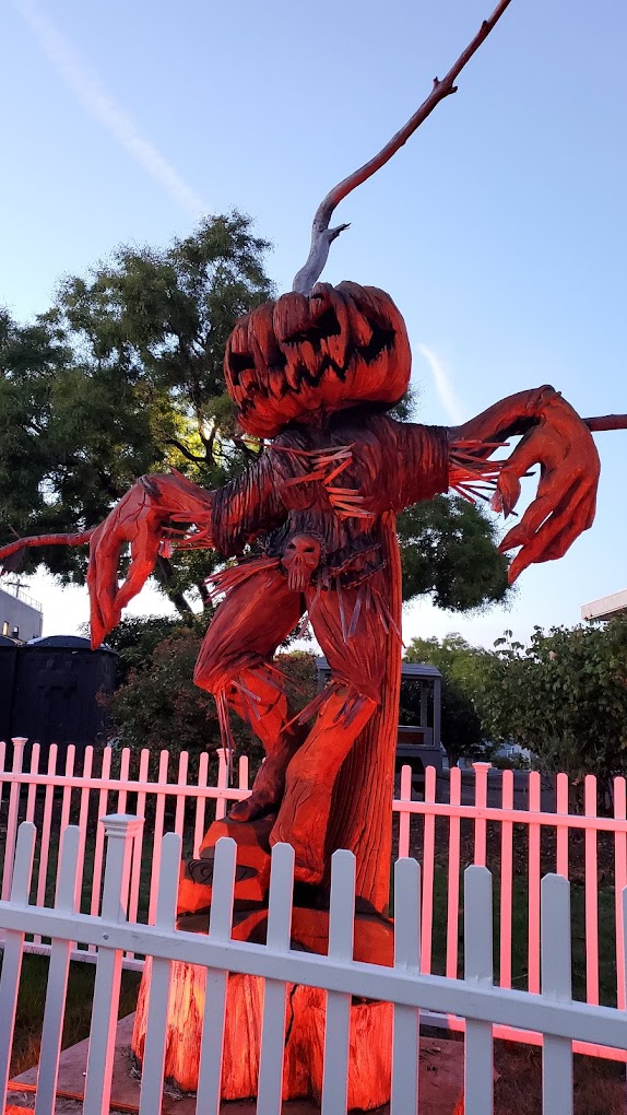 A large, spooky carving of a pumpkin head scarecrow.