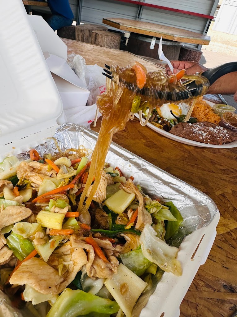 A white Styrofoam box filled with delicious looking Thai food.