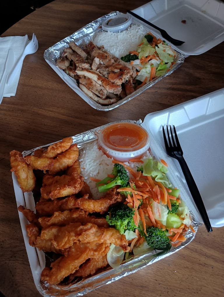 Two white Styrofoam boxes filled with delicious looking Thai food.