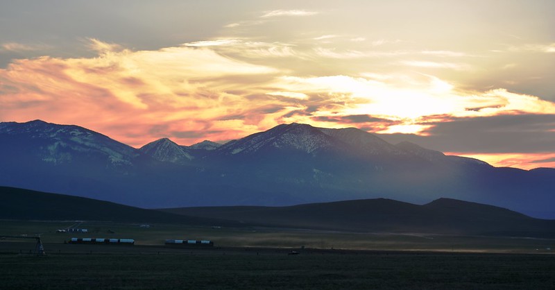 The sun sets in brilliant shades of pink and light orange over the Elkhorn Mountains.