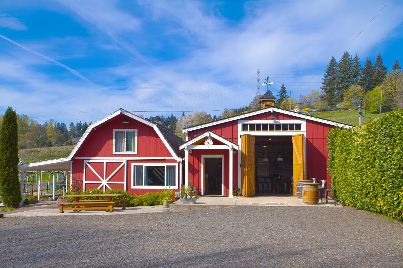 The outside of The Kitchen At Middleground Farms. It's a red barn next to a red building. It's cute.