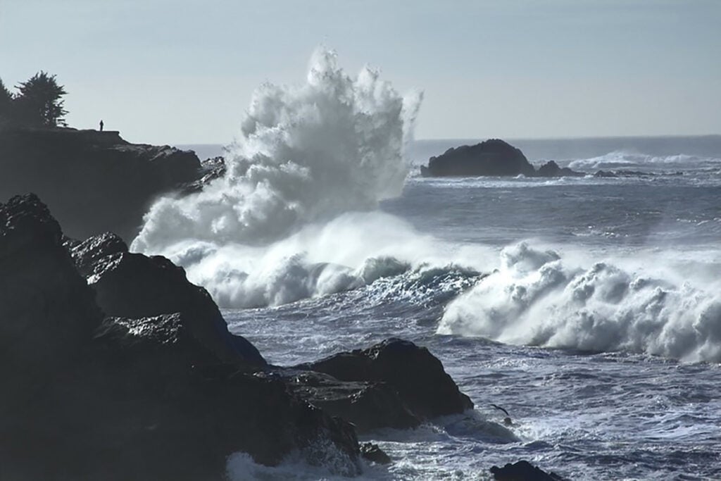 A large wave crashes on rocks at the Oregon coast.