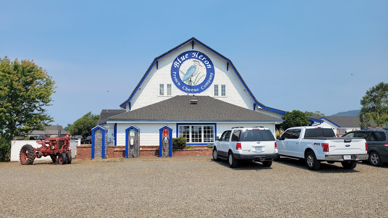 The exterior of the Blue Heron building. It's a large white building with a black roof and blue accents.