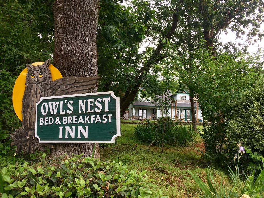 A green sign outside the Owl's Nest Inn.