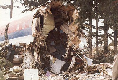 The fuselage of Flight 173 sitting in the wreckage of trees and buildings.